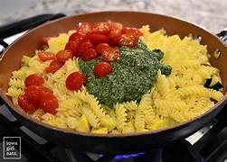  combinig pasta , veggies and sauce.